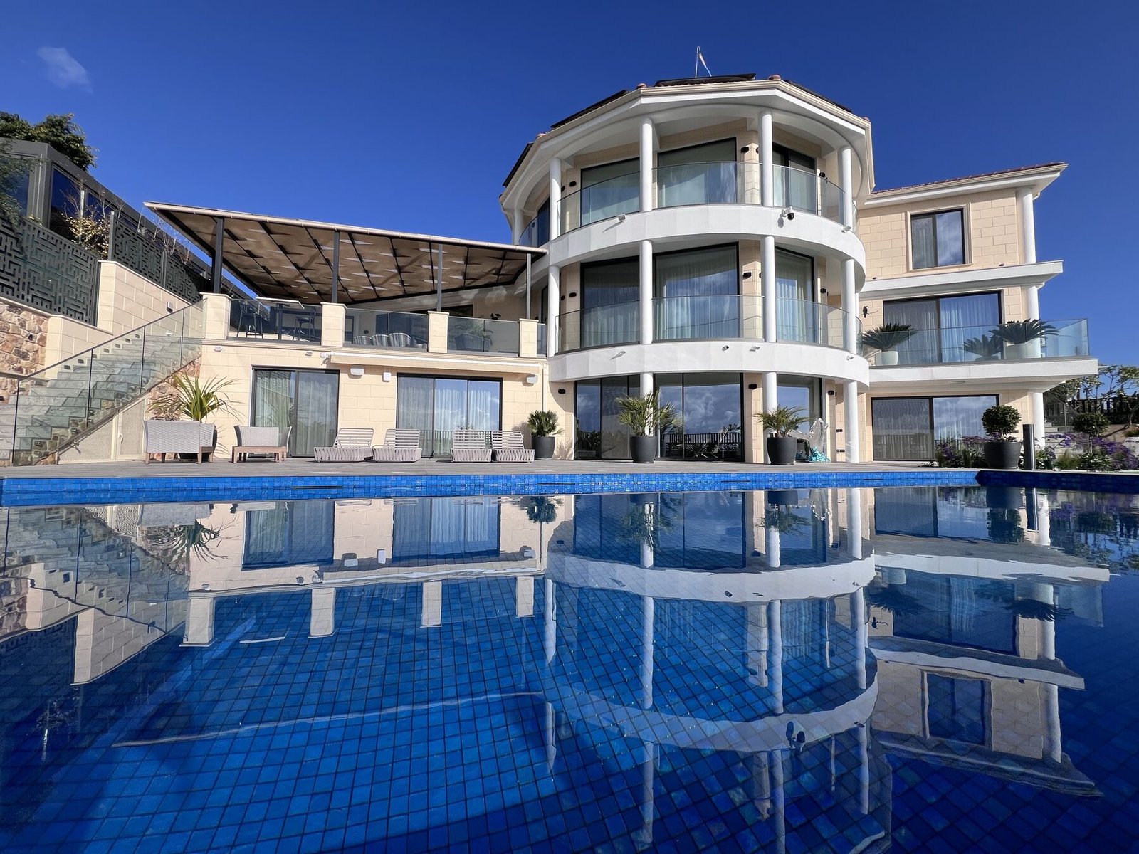 Garden Villa — curved glass façade reflected in the pool
